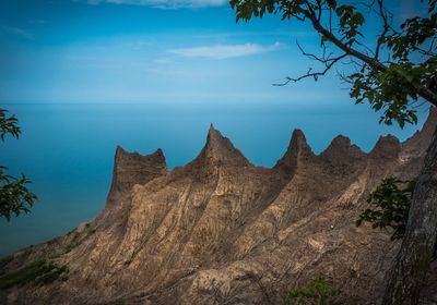 Scenic view of sea and mountains against blue sky