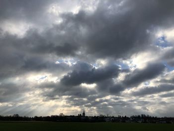 Scenic view of field against cloudy sky