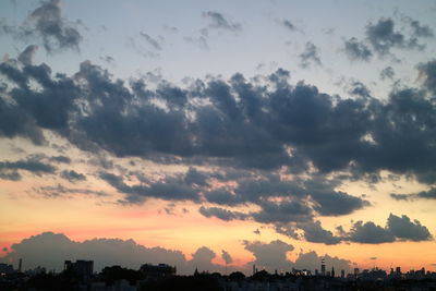 Silhouette city against sky during sunset