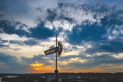 Low angle view of text on building against sky during sunset