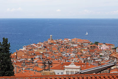 High angle view of townscape by sea against sky