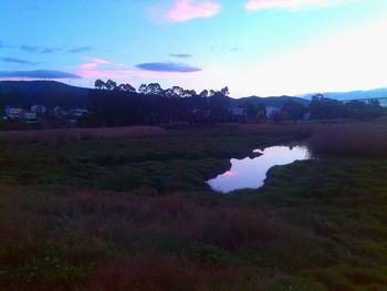 Scenic view of river against sky at sunset