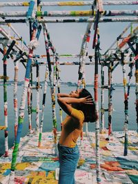 Rear view of woman standing against multi colored water