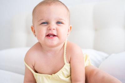 Portrait of cute baby boy lying on bed at home