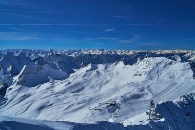 Scenic view of snowcapped mountains against blue sky