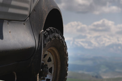 Suv wheel on the off-road adventure trail against the backdrop of mountains in the clouds