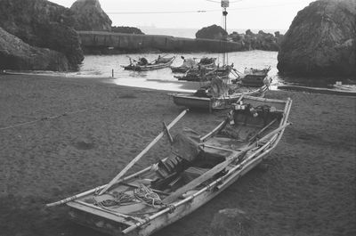 Boats moored on beach against sky