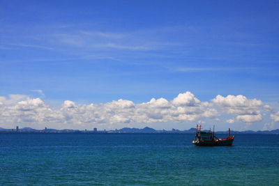 Boats sailing in sea against blue sky