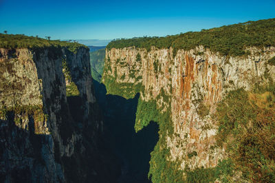 Itaimbezinho canyon with steep rocky cliffs going through a flat plateau, in cambará do sul, brazil.