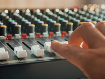 Cropped hand of male dj playing music on sound mixer