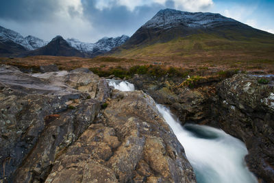 Scenic view of waterfall against sky