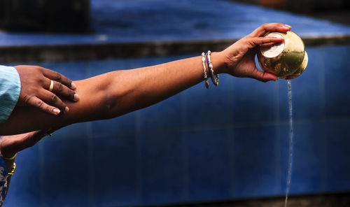 Cropped hand pouring water from container