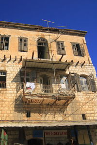 Low angle view of old building against blue sky