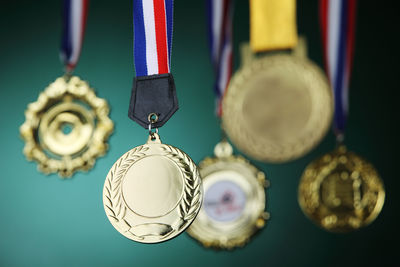 Close-up of gold medals against blackboard