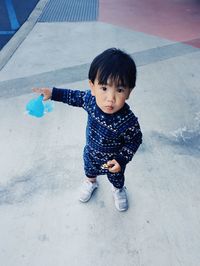 High angle portrait of cute boy standing on footpath