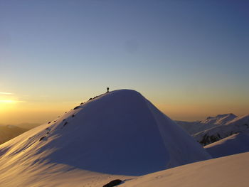 Scenic view of snowcapped mountains against sky during sunset