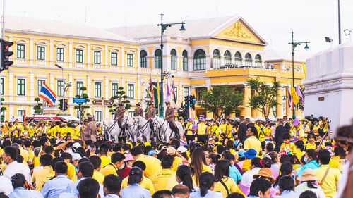 Group of people on city street against buildings