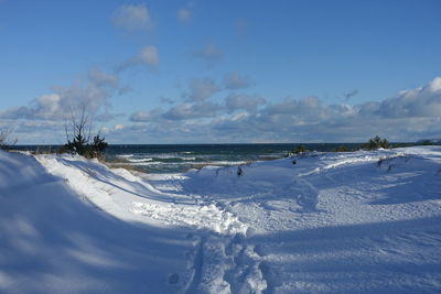 Scenic view of snow covered land against sky