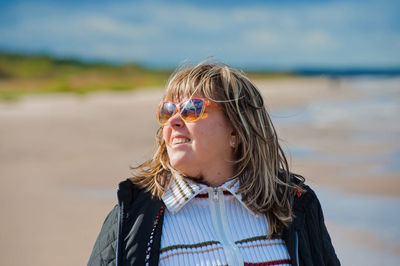 Smiling woman wearing sunglasses at beach