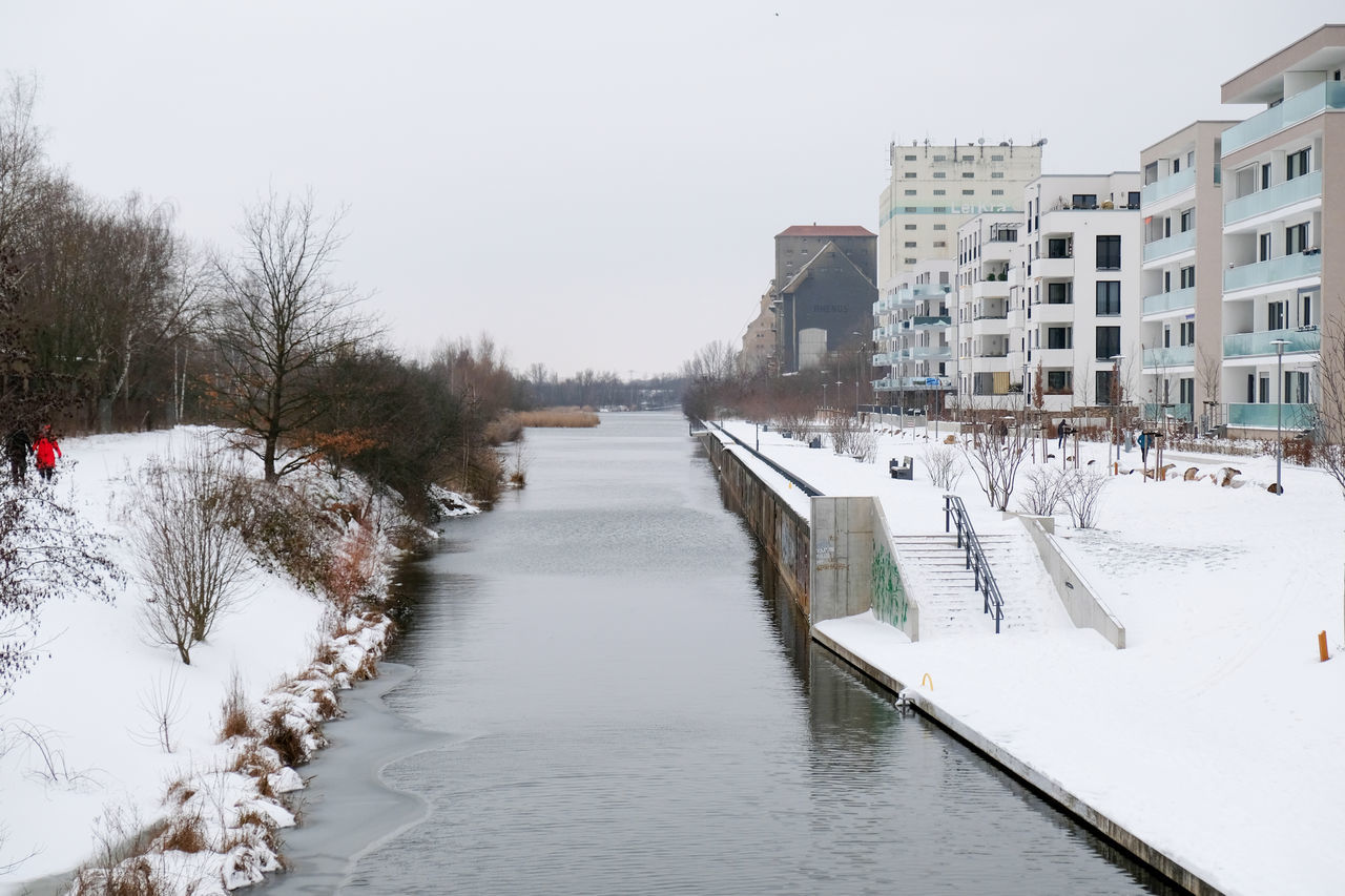 CANAL AMIDST FROZEN BUILDINGS IN CITY