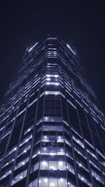 Low angle view of illuminated skyscraper against sky at night