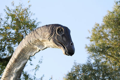 Low angle view of animal sculpture against clear sky