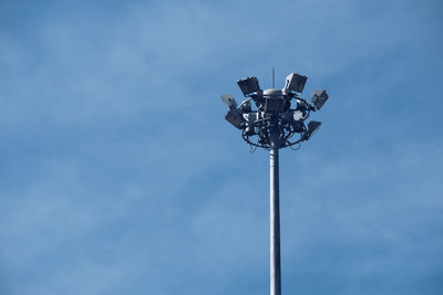 Low angle view of floodlight against blue sky