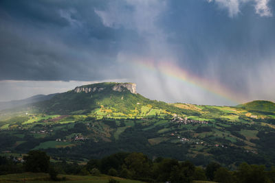 Scenic view of rainbow over landscape against sky