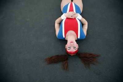 Portrait of sports woman wearing old-fashioned costume lying down on track