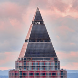 Low angle view of modern building against cloudy sky