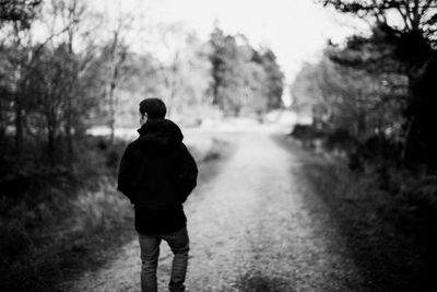 Rear view of man walking on field