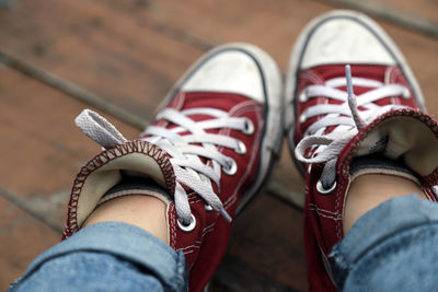 Low section of person in canvas shoes on hardwood floor