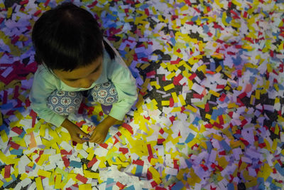 High angle view of girl on colorful confetti