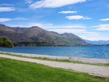 Scenic view of sea and mountains against blue sky