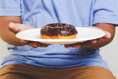 Midsection of man holding ice cream in plate