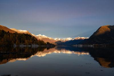 Scenic landscape with snowy mountains and Åndalsnes town on distant shore. panoramic view.