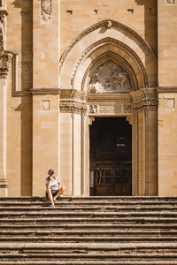 Full length of woman standing by staircase outside building