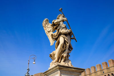 Low angle view of statue against blue sky