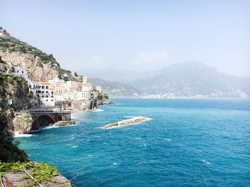 Scenic view of sea by buildings against sky