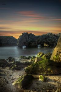 Geological formations at sunset on the cuevas del mar beach in llanes, asturias, spain.