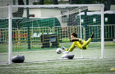 Male goalie playing soccer on field