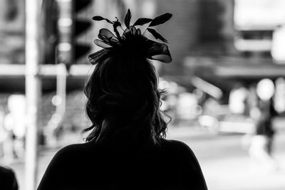 Rear view of woman standing against city