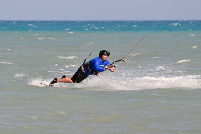 Full length of man kiteboarding in sea