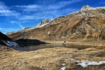 Scenic view of lake and snowcapped mountains against sky