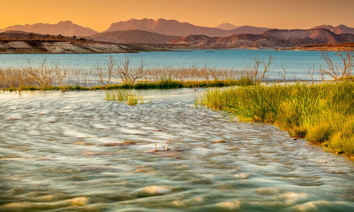 Scenic view of lake against sky during sunset