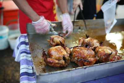 Close-up of man preparing food on barbecue grill