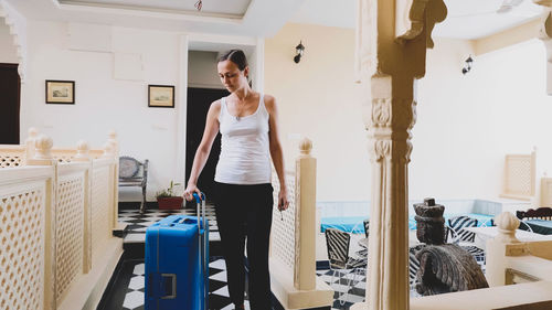 Woman carrying suitcase at hotel