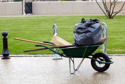Garbage bag on wheelbarrow against lawn