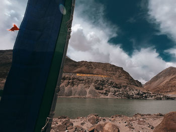 Scenic view of lake by mountains against sky