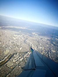 High angle view of airplane flying over city